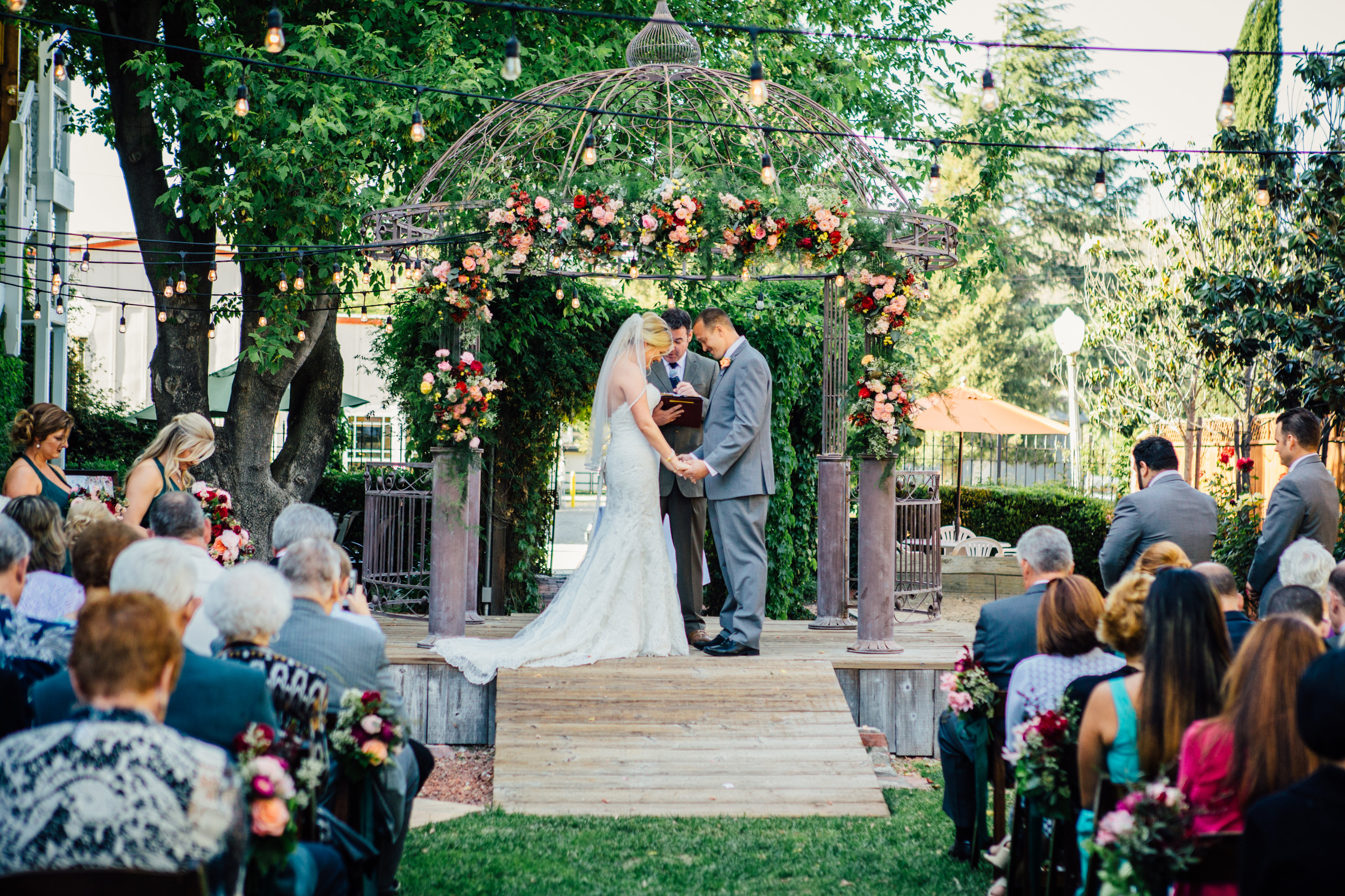 Bride and Groom under a ceremony arch with lush bright florals