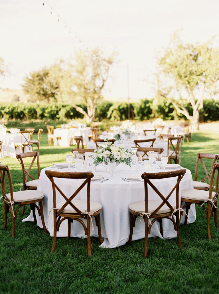 Round reception tables on grassy lawn at California winery