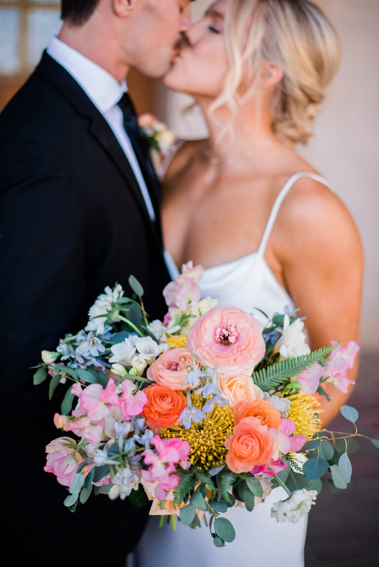The bride's lush bouquet was filled with ranunculus, garden spray roses, protea, sweet peas, scabiosa flower