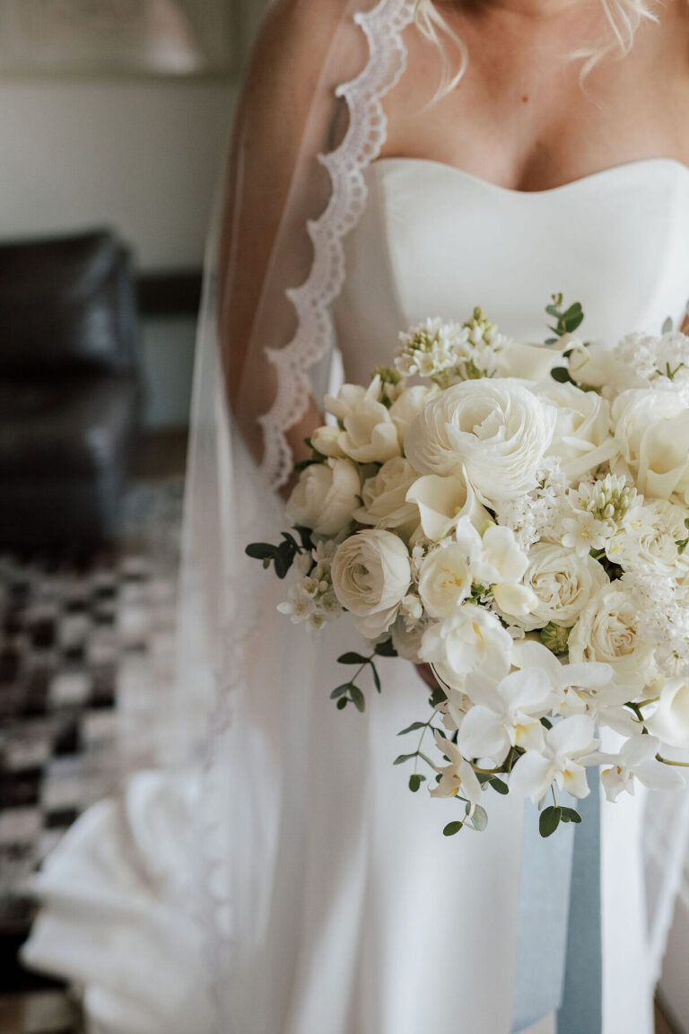 Bridal bouquet filled with ranunculus, Spring lilac, freesia, garden spray roses, mini calla lilies, orchids and roses